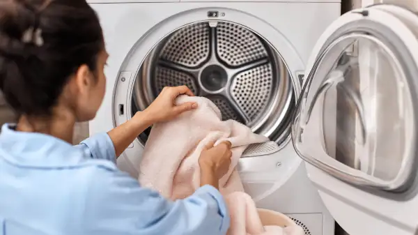 a caretaker putting close in a dryer