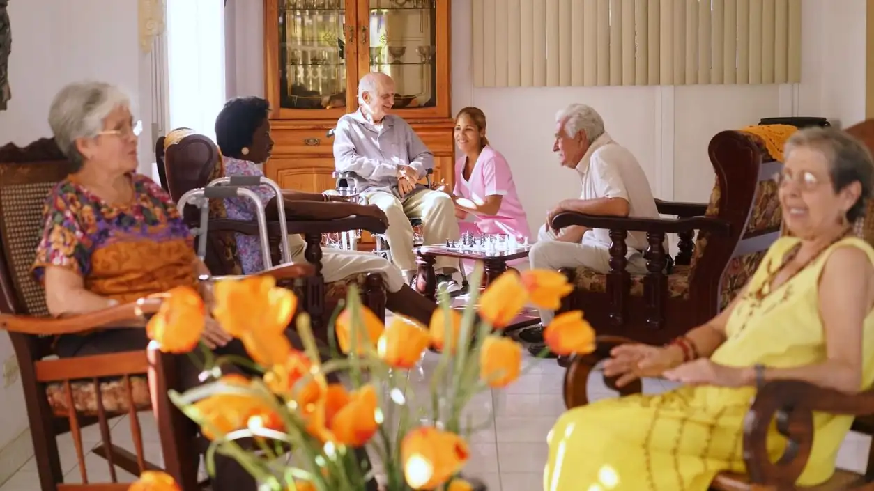 a day room with may older people sitting together talking