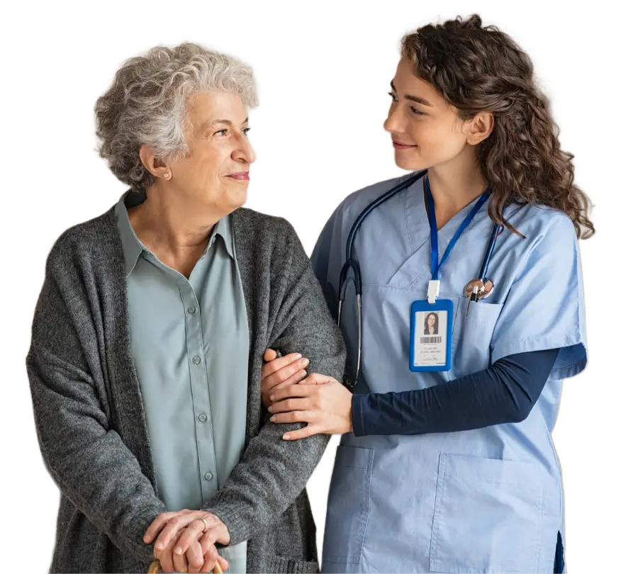 a younger caretaker standing with an older woman are-in-arm with her smiling