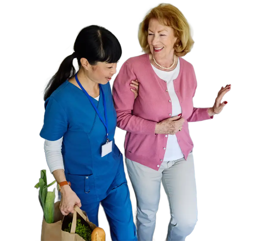 a younger caretaker holding the arm of an older woman, steading her while she walks and helps her with her groceries